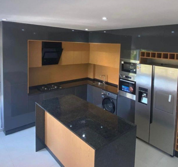 Cozinha preta em termo laminado alto brilho e pedra negro