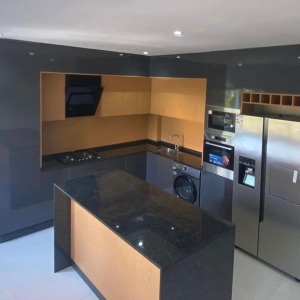 Cozinha preta em termo laminado alto brilho e pedra negro